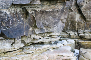 mountain textures of stones with interlayers of gypsum, colored quartz, clay, sand and other layers of various ores, with different textures, color and density, in gypsum ore quarry.