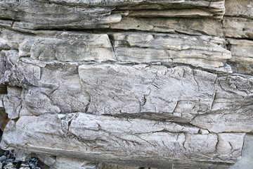 mountain textures of stones with interlayers of gypsum, colored quartz, clay, sand and other layers of various ores, with different textures, color and density, in gypsum ore quarry.
