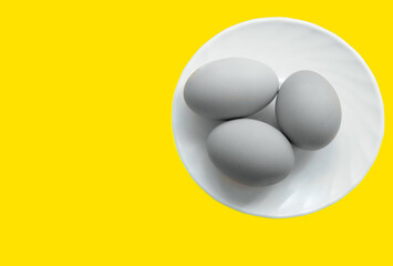 Illuminating and Ultimate Gray background. gray eggs on a yellow background. Abstract photography of eggs