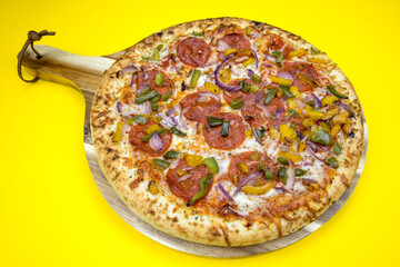 pizza au chorizo, poivrons et oignons rouges sur une table