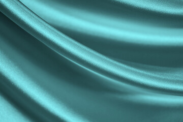 Elegant blue green background. Pale turquoise silk satin fabric. Shiny fabric flowing in waves....