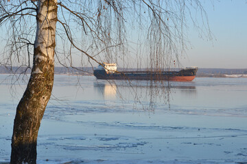 Cargo ship in sea full of ice in winter
