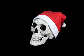 Human skull in red Santa Claus hat with white trim and pompon, Isolated on black background.
