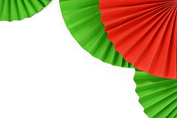 Red and green paper craft rosettes in traditional Christmas colors on side of and top of white...
