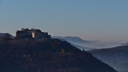 Obraz premium Beautiful view of historic castle ruin Hohenneuffen on the foothills of Swabian Alb, Germany in the morning sun in late autumn with foggy air in the surrounding valleys.