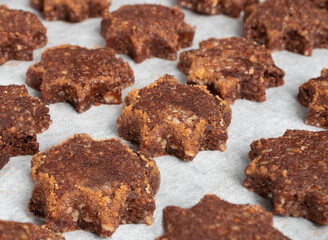 Rows of gluten free almond flour and chocolate cookie in shape of a star with sugar cinnamon rim, ready to be baked. Swiss recipe 