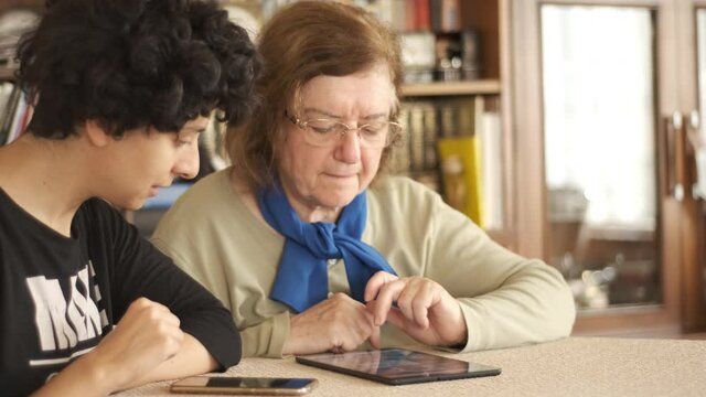 Tablet. Senior adult learning to use digital technology device. Touching screen.