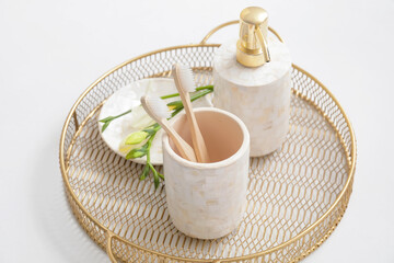 Tray with dispenser and toothbrushes on white background