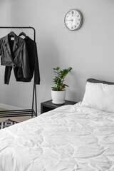 Interior of stylish bedroom with clothes rack