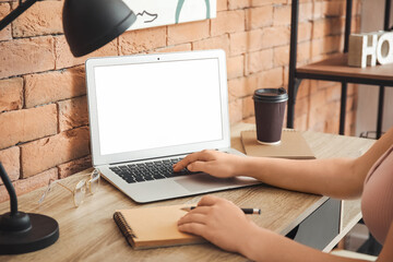 Young woman using laptop in office