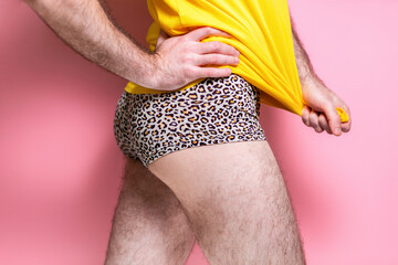 Male stripper in leopard shorts, posing with his hand on the belt, pulling the shirt down. Side...