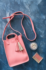 Stylish bag and cosmetics on color background