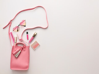 Stylish bag with cosmetics on light background