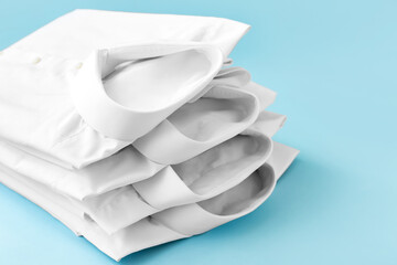 New male shirts on color background