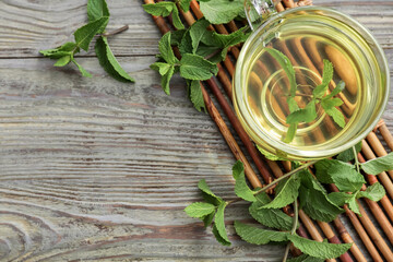Cup of green tea with mint on wooden table