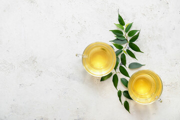 Cups of green tea on light background