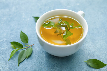 Cup of green tea on color background