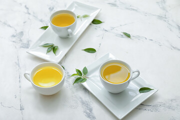 Obraz na płótnie Canvas Cups of green tea on light background