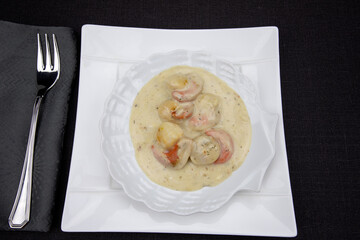 saint-jacques cuisiné avec sauce dans une assiette