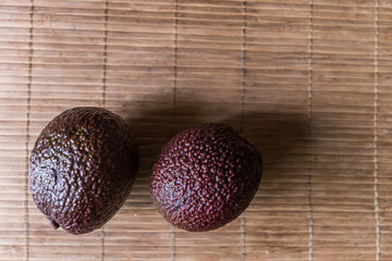 Two dark purple avocados ready to eat