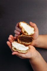 Profiteroles with different flavors. French dessert in children's hands.