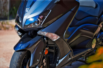 Closeup of Headlights of Modern City Motorcycle Standing Outdoor.