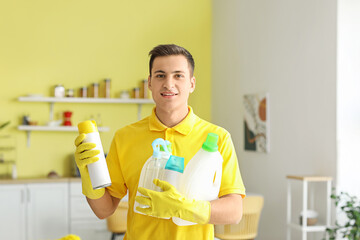 Young man with cleaning supplies at home