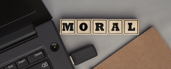 The word MORAL made from wooden cubes. Top view