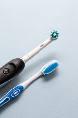 Brushing Heads of Professional Electric Toothbrush and Manual Brush on Blue  Background.
