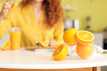 Bowl with fresh oranges on kitchen table