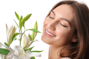 Beautiful young woman with fresh lilies on white background