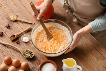 Woman preparing pumpkin pie on table