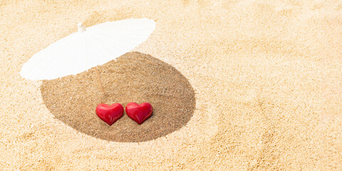 Fototapeta na wymiar St. Valentine Day and February 14th concept. Two red hearts - symbol of love couple on sand paradise tropical beach under parasol. Love, togetherness, marriage. Traveling together. Banner. Copy space