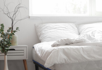Bed with comfortable orthopedic mattress in room