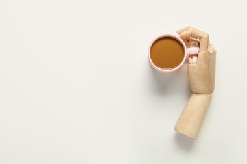 Wooden hand and cup of coffee on white background