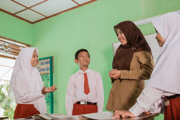 Indonesian school students with their teacher have a discussion in the class