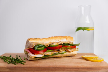 Fresh submarine sandwich with ham, cheese, tomato, cucumber, lettuce and onion isolated on white background.