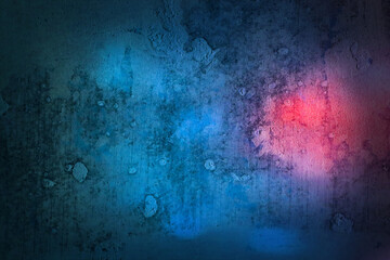 Grunge dark color background. Texture concrete wall with bright blue or azure and pink light spots. Horizontal photo with neon for modern design