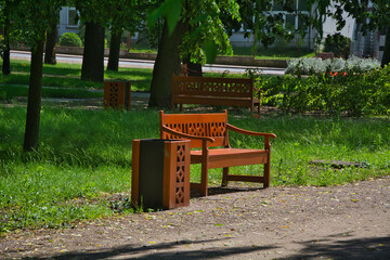 A bench and a garbage can in a public park.