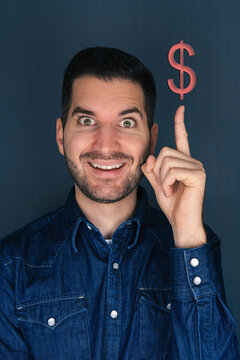 Mann zeigt mit Zeigefinger auf ein Dollar Zeichen