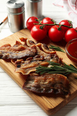 Concept of tasty snack with fried bacon on wooden background