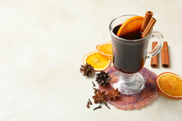 Glass of mulled wine and ingredients on white background