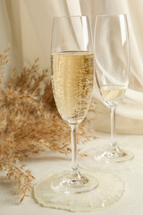 Champagne glasses, epoxy resin and field flowers on white table