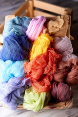 Top view on many multi-colored gauze (cheesecloth) in a wooden box