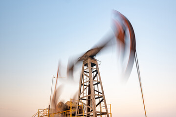 oil rig silhouette working at sunset. Blur at slow shutter speeds