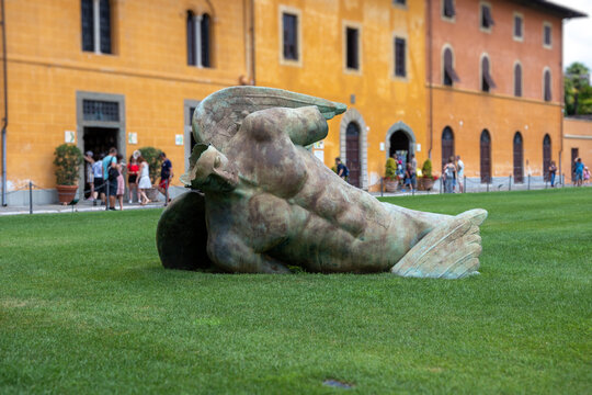 Sculpture of Fallen angel (Angelo caduto) on the lawn in the grass, Pisa, Italy