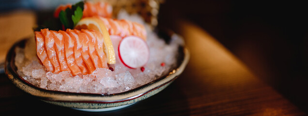Copy space in horizontal banner close-up with traditional Japanese sashimi salmon on a decorated...