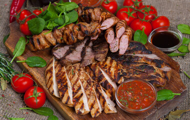 Mixed grilled meat platter. Assorted delicious grilled meat with vegetable. Mixed grilled meat with pepper sauce and vegetables.