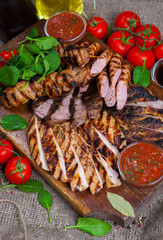 Mixed grilled meat platter. Assorted delicious grilled meat with vegetable. Mixed grilled meat with pepper sauce and vegetables.