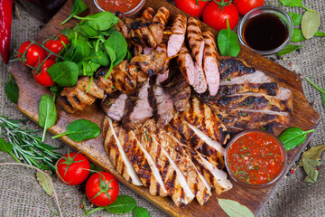 Mixed grilled meat platter. Assorted delicious grilled meat with vegetable. Mixed grilled meat with pepper sauce and vegetables.